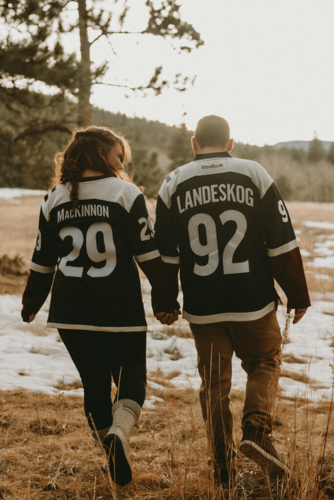 Outdoor Engagement in Colorado Couple Holding Hands Avalanche Jerseys | Julia Susanne Photography