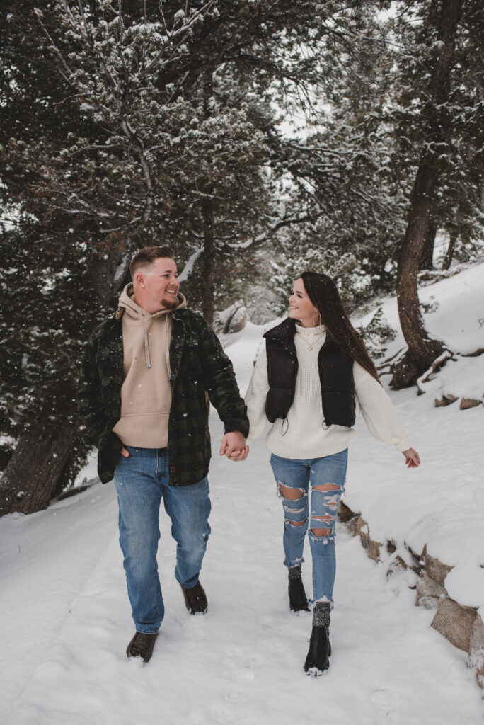 Outdoor Engagement in Colorado Couple Walking in Snow
